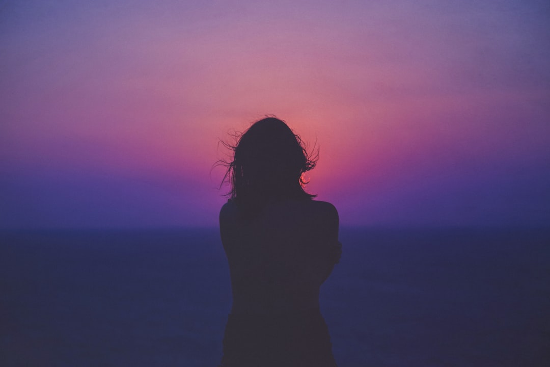 woman leaning against a wall in dim hallway