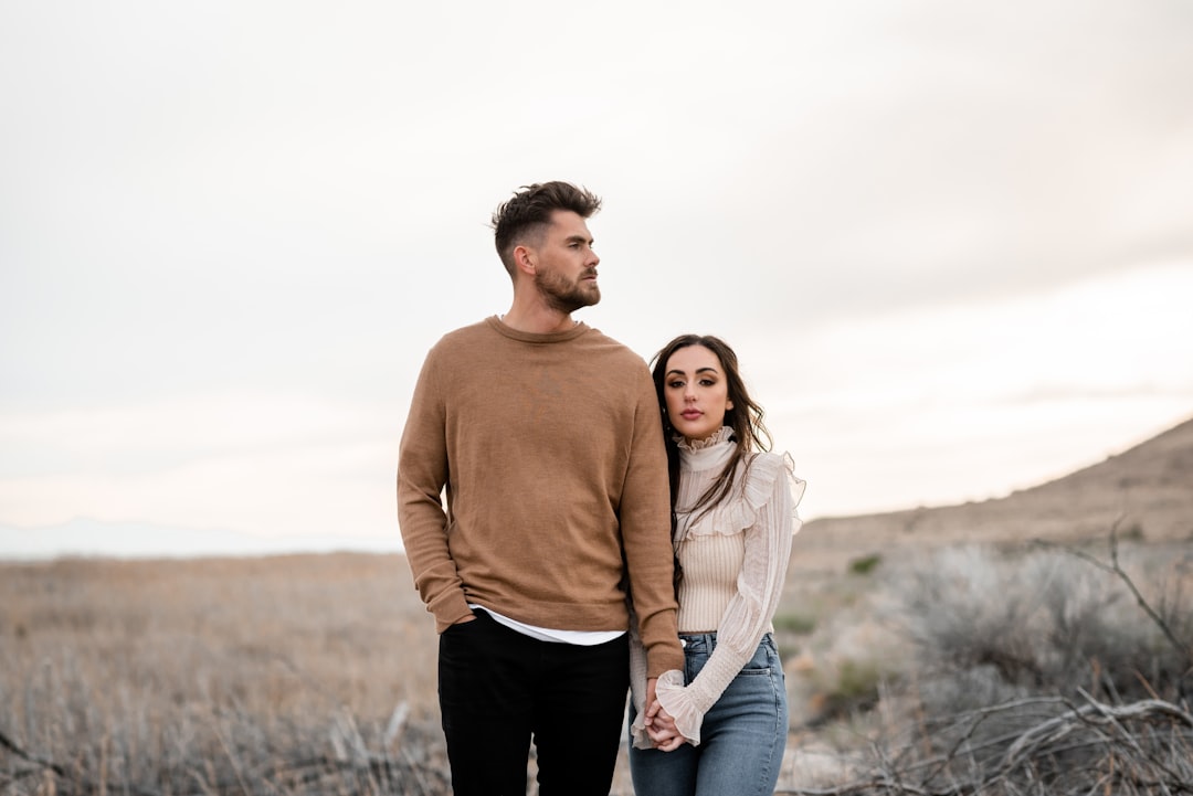 a man and a woman sitting on a dock looking at the water