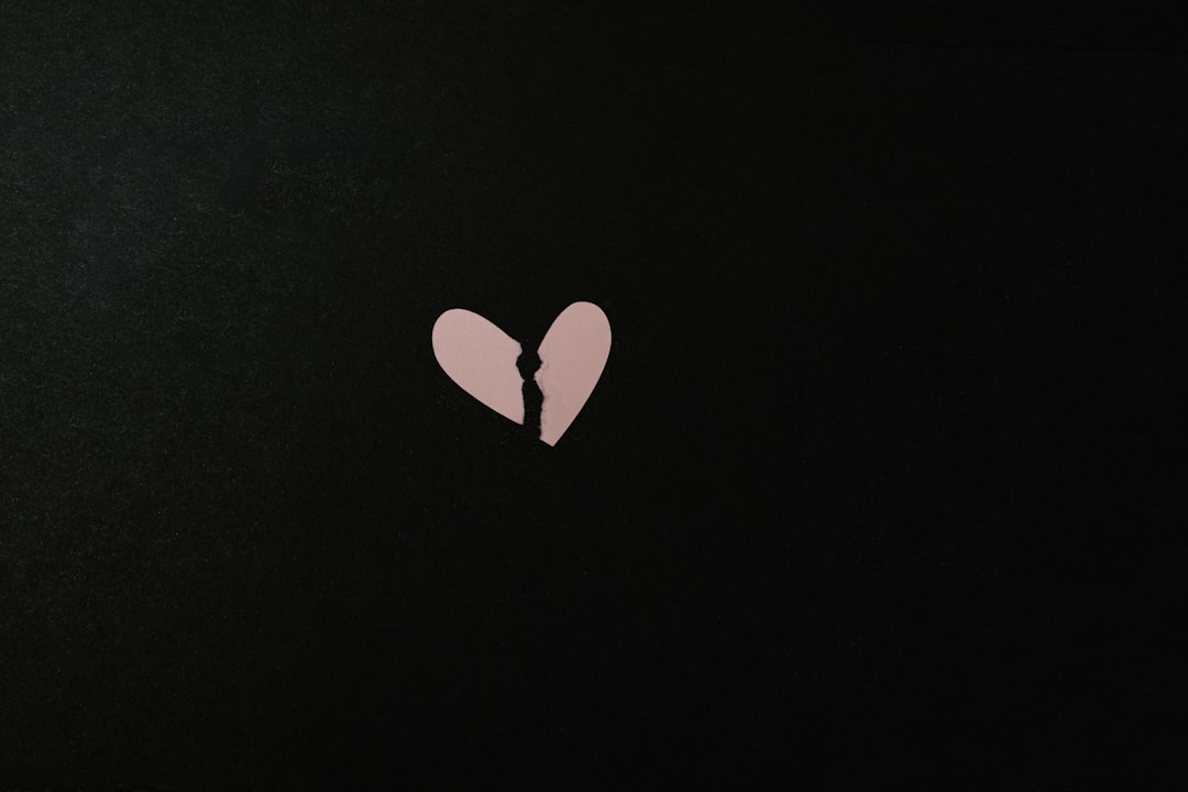 A broken heart shaped cookie sitting on top of a table